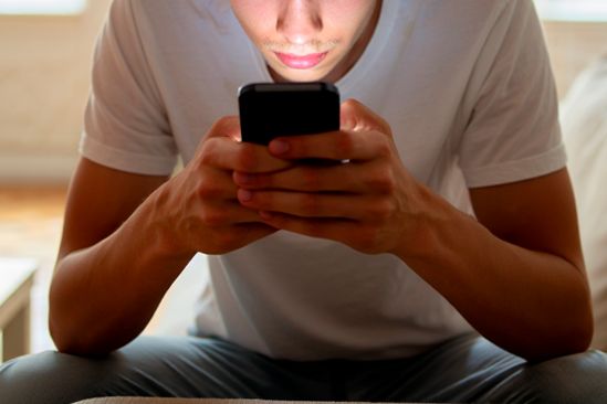 Мужчина сидит в телефоне Мужчина держит в руках телефон